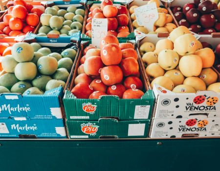 a fruit stand with apples, oranges, apples, and pears