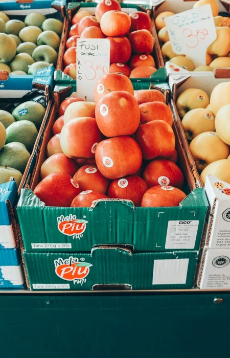a fruit stand with apples, oranges, apples, and pears
