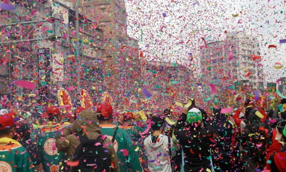 a group of people walking down a street surrounded by confetti