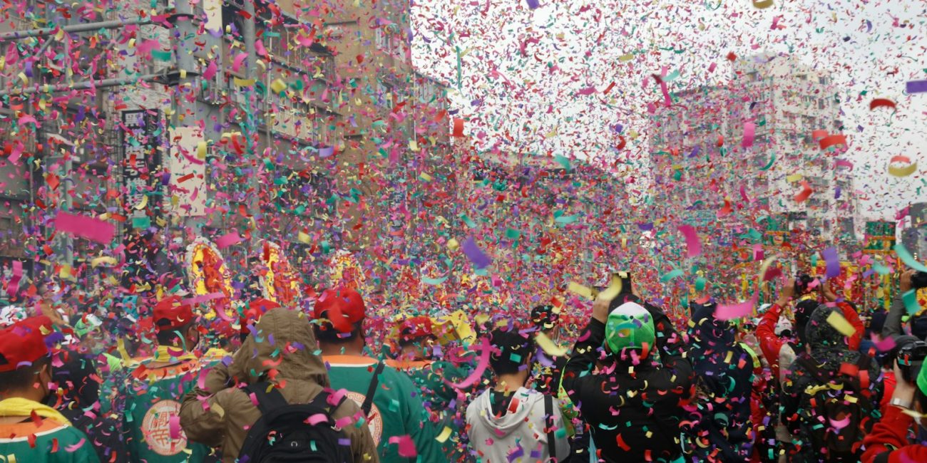 a group of people walking down a street surrounded by confetti