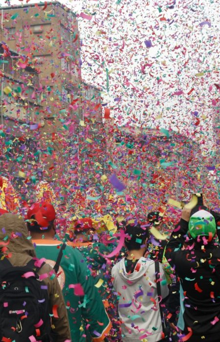 a group of people walking down a street surrounded by confetti