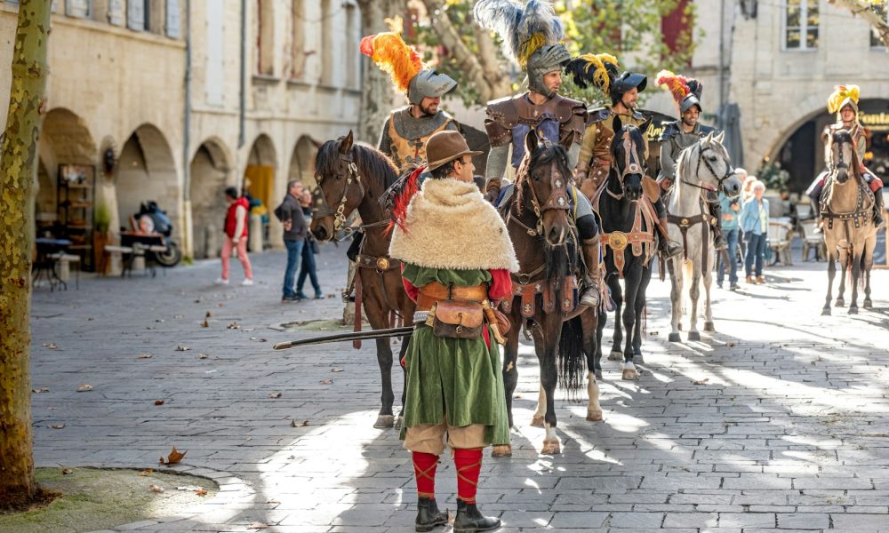 A group of people riding horses down a street