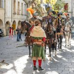 A group of people riding horses down a street