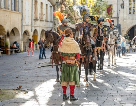 A group of people riding horses down a street