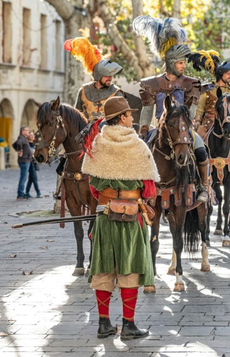 A group of people riding horses down a street