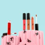 a couple of pink containers filled with different types of lipstick