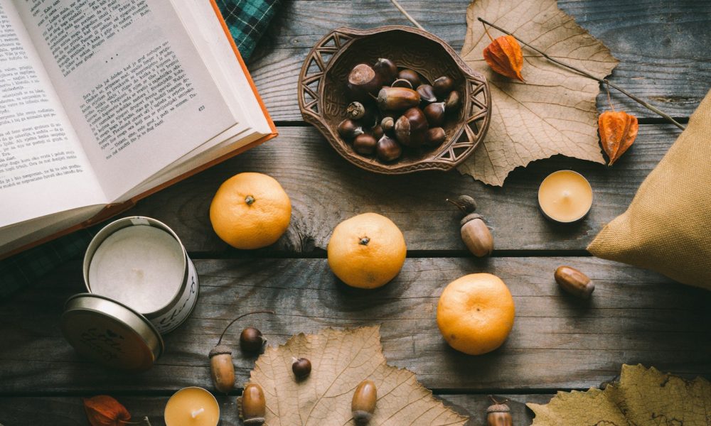 orange fruit beside black round plate on brown wooden table