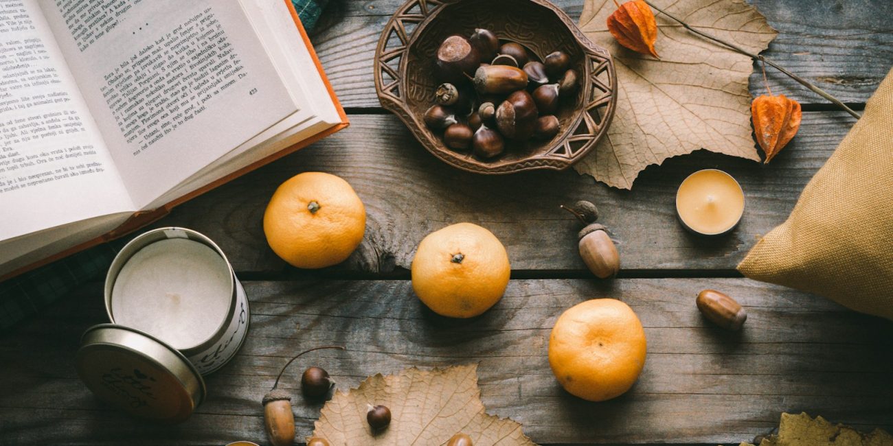 orange fruit beside black round plate on brown wooden table