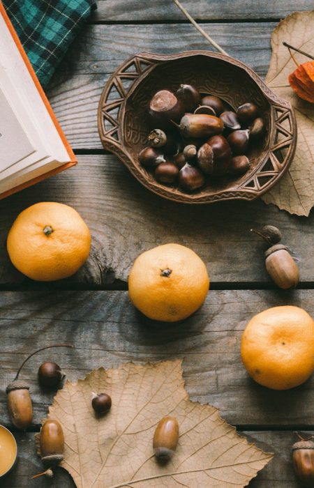 orange fruit beside black round plate on brown wooden table