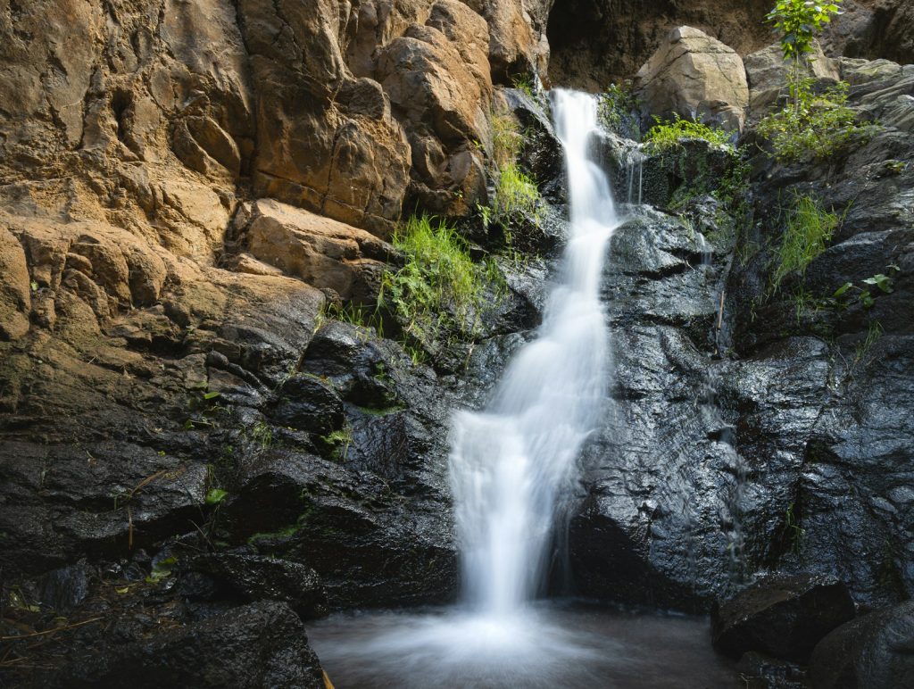 A gentle waterfall cascades down rocky terrain.