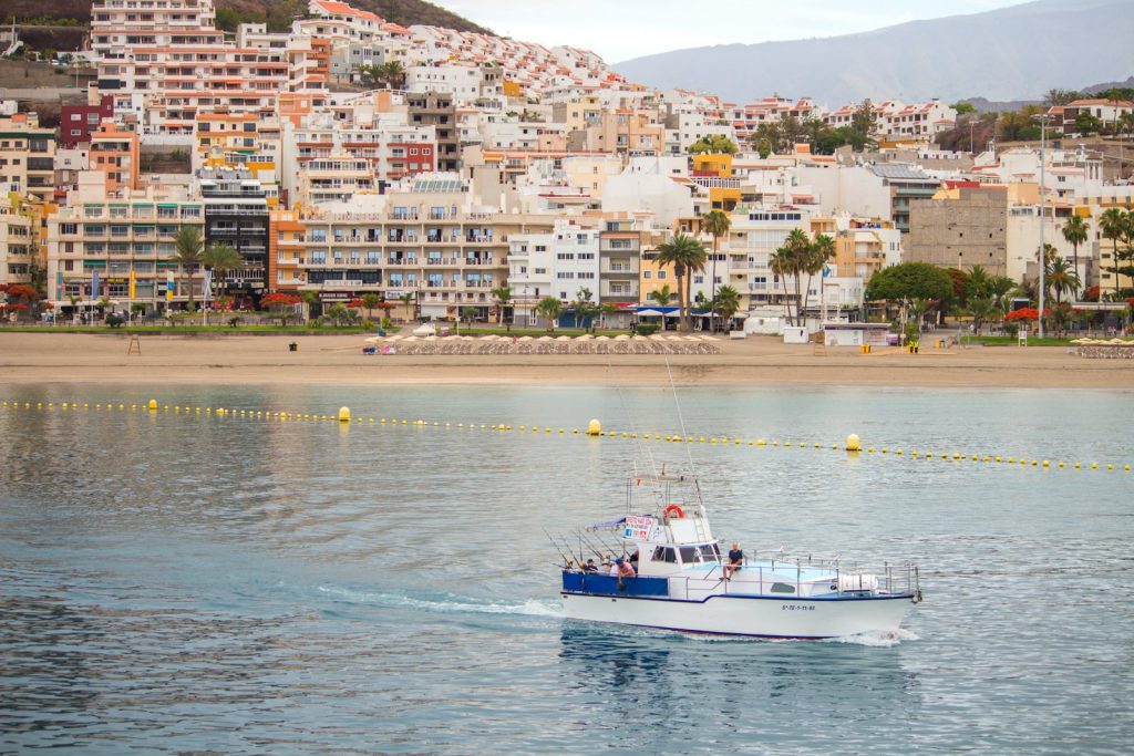 a boat traveling on the water in front of a city