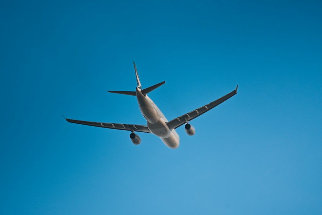 A large passenger jet flying through a blue sky