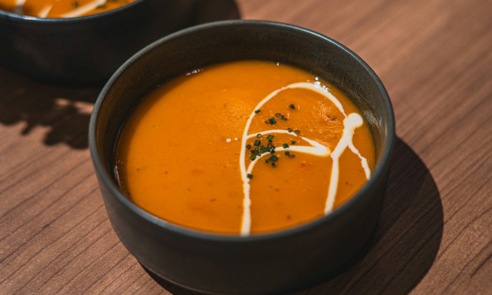 two bowls of soup on a wooden table