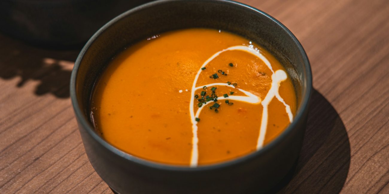 two bowls of soup on a wooden table