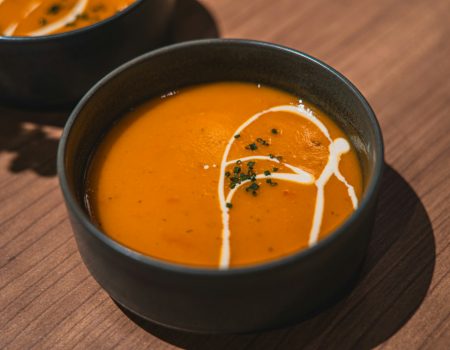 two bowls of soup on a wooden table