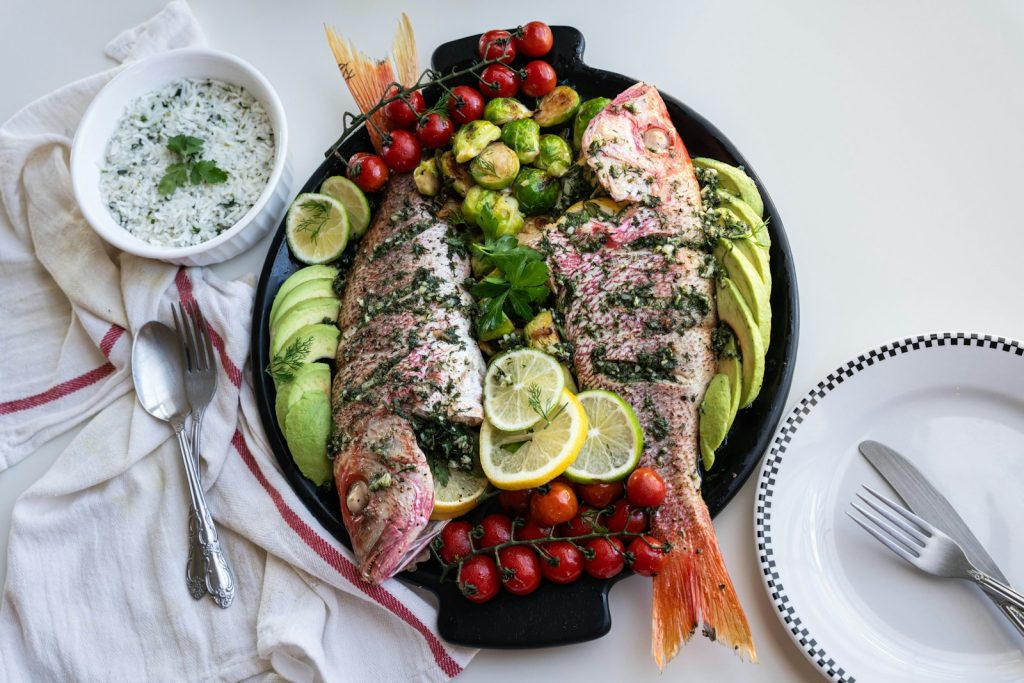 a platter of fish, tomatoes, cucumbers, avocado,
