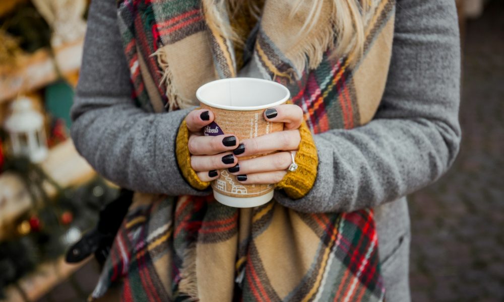 closeup photo of woman holding brown plastic cup in room