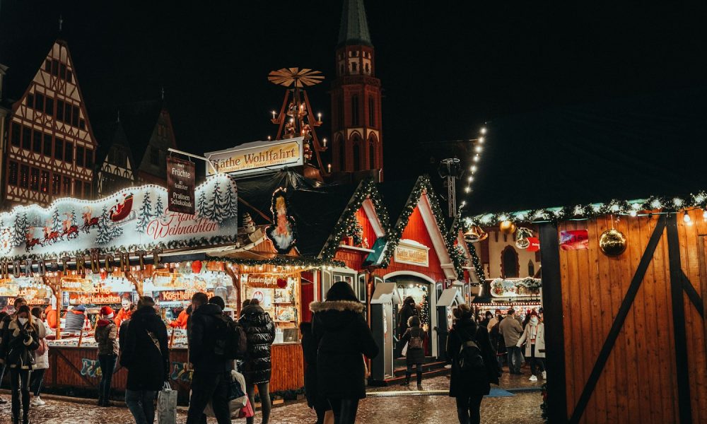 a group of people walking around a christmas market