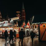 a group of people walking around a christmas market