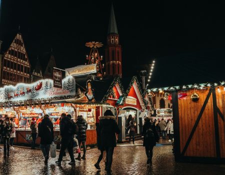 a group of people walking around a christmas market