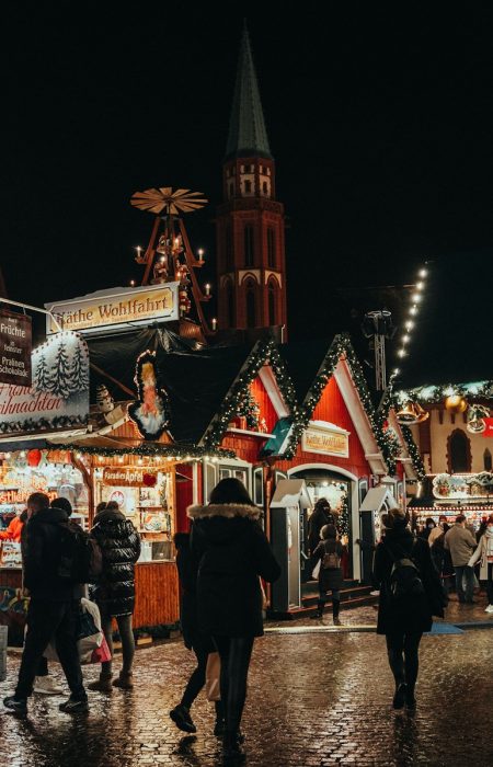 a group of people walking around a christmas market
