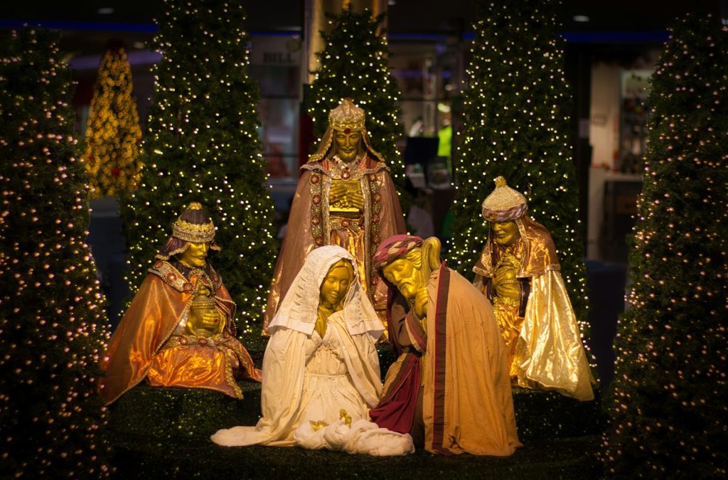 Nativity scene figures with golden masks and jewel-toned robes