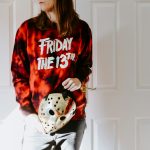 a woman in a tie dye shirt holding a dice bag