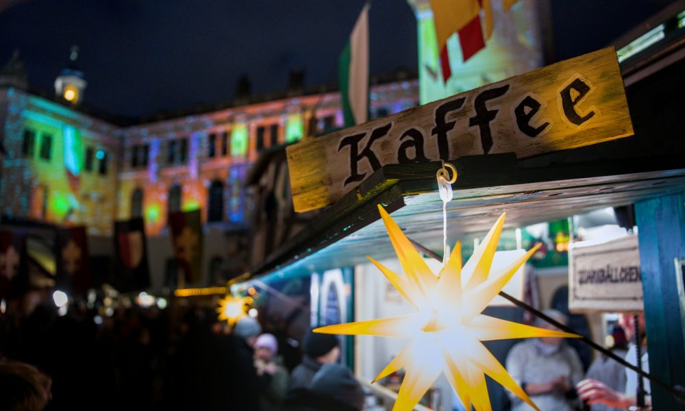 Kaffee sign at a night market with festive lights.