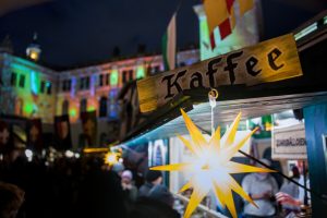 Kaffee sign at a night market with festive lights.