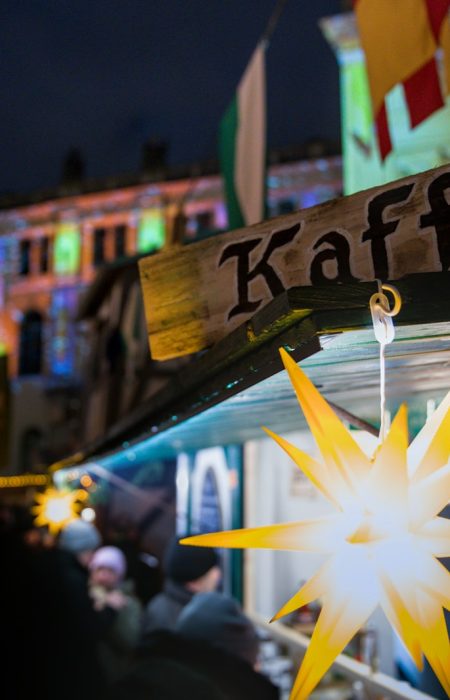 Kaffee sign at a night market with festive lights.
