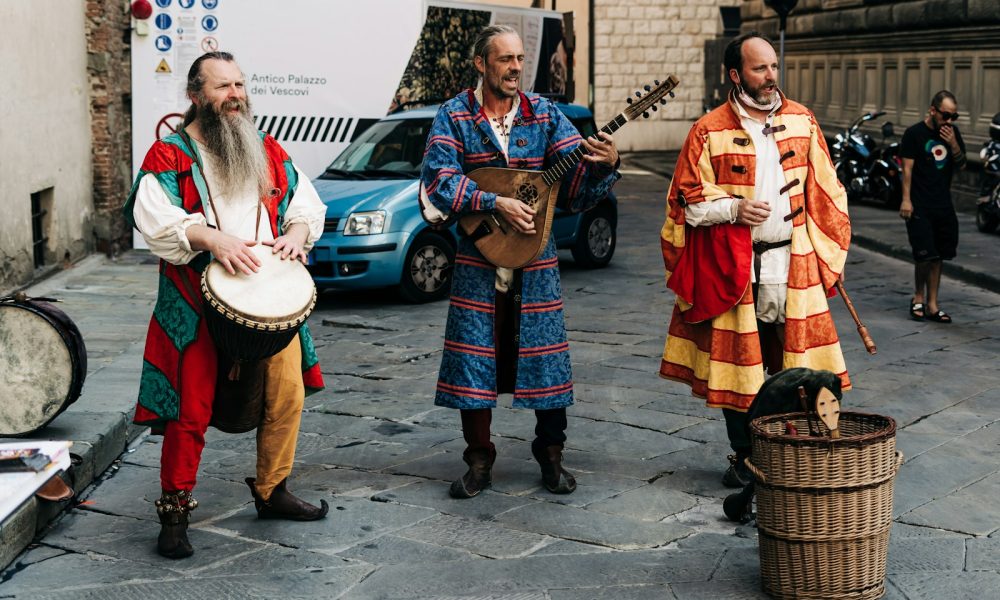 2 women in traditional dress standing beside blue car during daytime