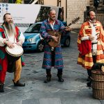 2 women in traditional dress standing beside blue car during daytime