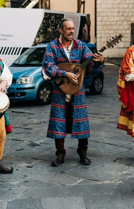 2 women in traditional dress standing beside blue car during daytime