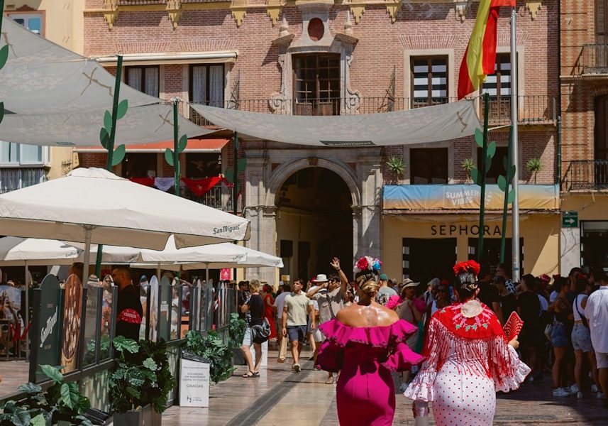 A couple of women walking down a street next to tall buildings